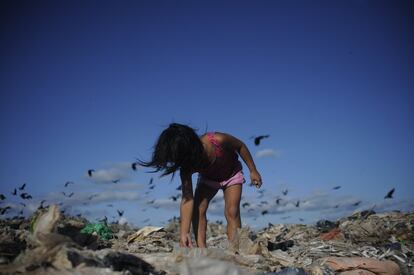 Yamila Reyes, en el vertedero de Pucallpa, con los buitres de fondo. Los recicladores ejercen su trabajo exponiéndose a todo tipo de enfermedades, pues beben del agua que proviene de los canales de agua subterránea contaminada y también sufren las consecuencias de la emisión del metano. De hecho, una investigación realizada en 2017 por la Universidad Nacional de Ucayali confirmó que el 70% de la población que reside aquí padece patologías asociadas con la respiración como asma, disnea, gripe, tos e intoxicaciones. Además, el 30% afronta otras dolencias, entre las que destacan los cólicos y el dengue. Y luego llegó la covid-19.