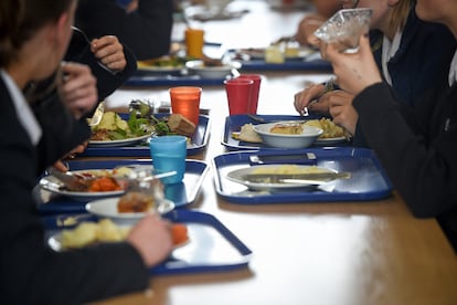 Varios estudiantes comen en sus bandejas en una escuela británica.