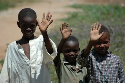 Tres niños saludan a la cámara en Darfur (Sudán) en 2005.