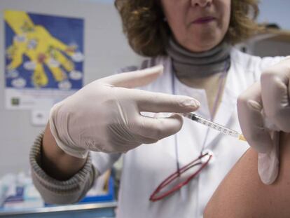 Una enfermera inyecta una vacuna en el brazo de un paciente