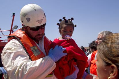 Un miembro del equipo de salvamento marítimo con una niña que viajaba en una de las pateras que han cruzado el Estrecho. 