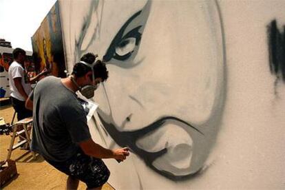 Dos artistas acabando sus creaciones, ayer, en la demostración de grafito en el parque Central de Mataró.