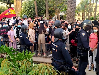 Miembros de la Policía Nacional ante un grupo de manifestantes congregados en Ceuta, este lunes.