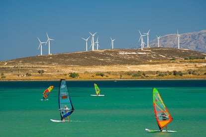 Windsurferos con fondo de molinos de viento.