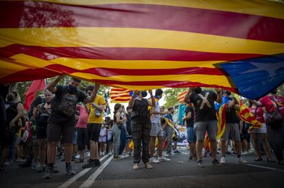 Varios CDR sostienen una enorme bandera independentista durante la protesta por el paseo de Gràcia hasta la plaza de Urquinaona de Barcelona.