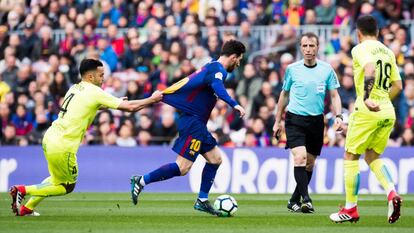 Bruno González sujeta la camiseta de Messi durante una jugada.