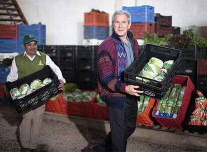 El presidente Bush lleva una caja de lechugas en la estación de Labradores Mayas de Guatemala ayer.