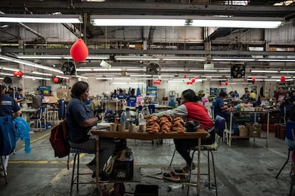 Trabajadores dan forma al cuero para zapatos en la planta de producción de Calzado Rómulo en Yumbo, en Colombia.