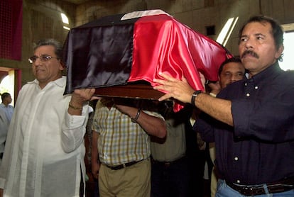 Humberto Ortega, a la izquierda y su hermano Daniel Ortega, llevan el ataúd de su madre, Lidya Saveedra, cubierto con una bandera sandinista, en la catedral metropolitana, en Managua, el 4 de julio de 2018.