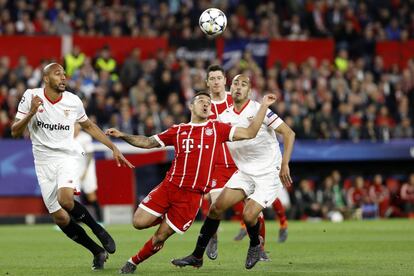 El jugador del Bayern Thiago trata de hacerse con la posesión del balón ante la presión del jugador del Sevilla Guido Pizarro.