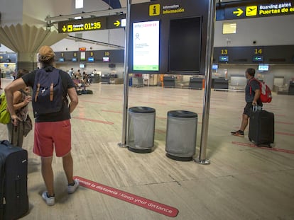 Pasajeros miran las pantallas informativas en la terminal de salidas del aeropuerto de San Pablo, Sevilla, el 19 de agosto.