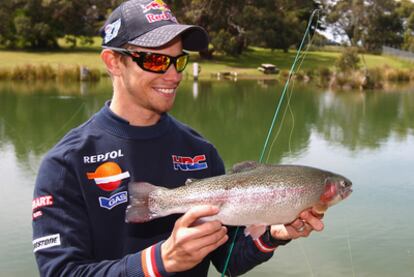 Stoner muestra una trucha pescada en Phillip Island.