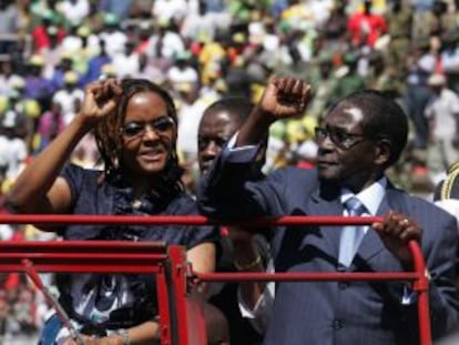 Robert Mugabe e sua mulher, Grace, acenam para o público na posse dele para o seu sétimo mandato presidencial, no Estádio Nacional, em agosto de 2013.