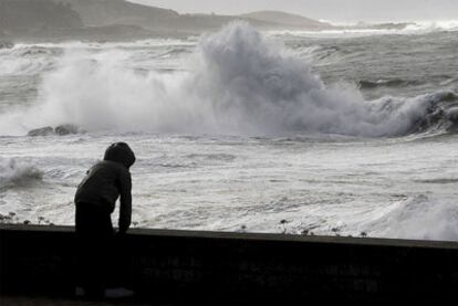 Una mujer observa el gran oleaje registrado en el municipio de Villagarcia de Arosa como consecuencia del temporal.