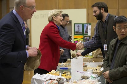 La senadora de Massachusetts, Elizabeth Warren (c), encaixa la mà del director del col·legi Tony Byers (2-d) a la seva arribada a un àpat després d'exercir el seu dret al vot al col·legi Graham and Parks School a Cambridge de Massachusetts (EUA).