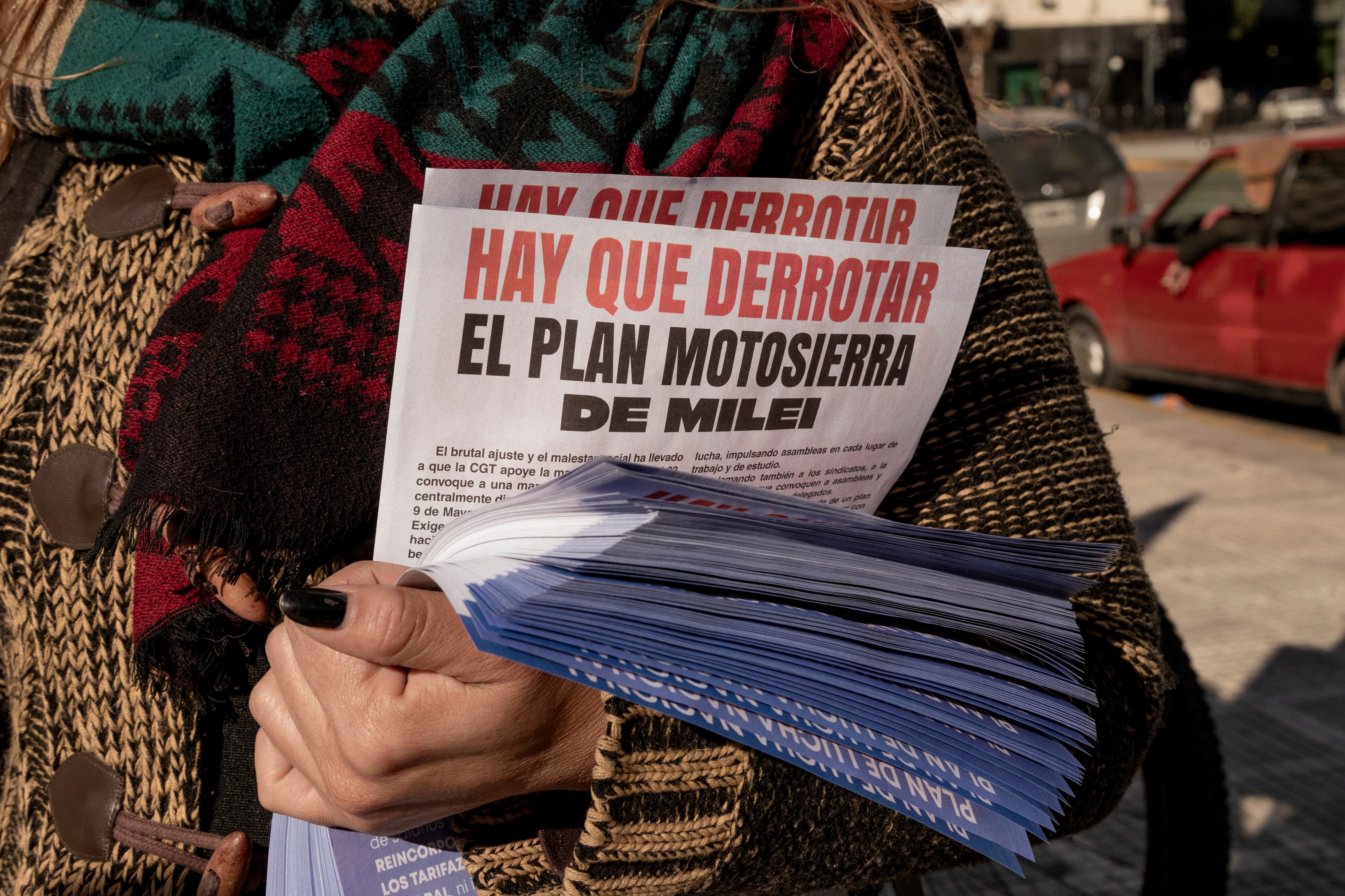 Una mujer sostiene volantes contra las medidas de Javier Milei  en Buenos Aires.