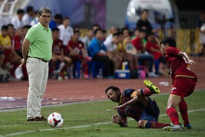 El entrenador del Barcelona, Gerardo Martino, observa la entrada de un jugador tailand&eacute;s sobre Xavi Hern&aacute;ndez.