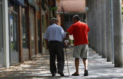 Un anciano camina el martes con un señor en el barrio de Valdezarza. Esta zona, en la que hay mucha gente joven, no cuenta con ninguna escuela infantil pública, pero la concejal del distrito quiere abrir una nueva.
