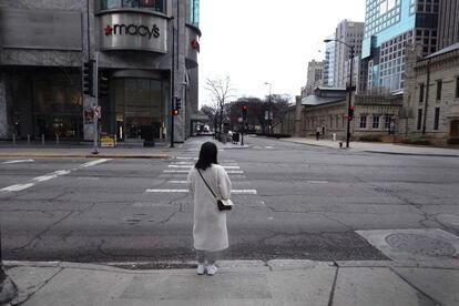 Una mujer espera a que cambie la luz antes de cruzar Michigan Avenue por el distrito comercial Magnificent Mile, en Chicago, Illinois.