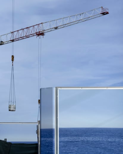 A construction site is concealed by a fence with an image of the sea, Monaco, 2022. 