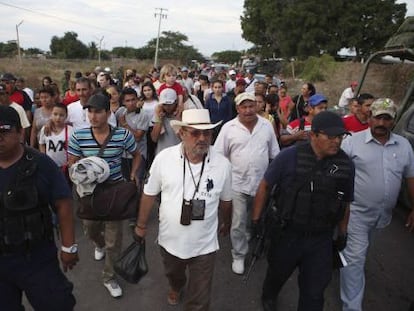 Hip&oacute;lito Mora (in the white hat) turns himself in to authorities.
 