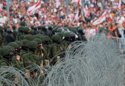 Oficiales de seguridad tras una concertina durante la manifestación contra Lukashenko, este domingo.