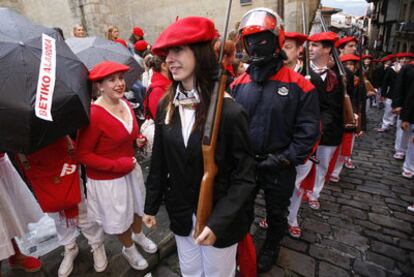 Miembros del Alarde mixto, custodiados por la Ertzaintza, son recibidos en Hondarribia con abucheos y paraguas negros.