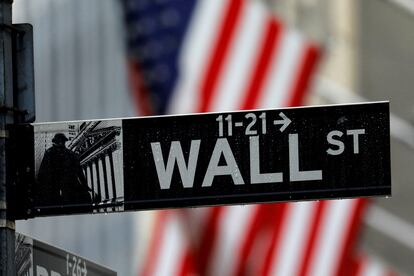 FILE PHOTO: Raindrops hang on a sign for Wall Street outside the New York Stock Exchange in Manhattan in New York City, New York, U.S., October 26, 2020. REUTERS/Mike Segar/File Photo