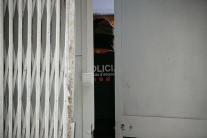 Agentes de los Mossos d'Esquadra en el interior de un local en la calle Sant Climent.