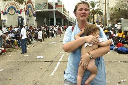 Una mujer busca ayuda para su hijo de 11 meses en los alrededores del Centro de Convenciones de Nueva Orleans.