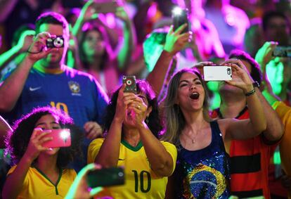 Torcedores fotografam a partida de vôlei entre Brasil e México, pela fase de classificação, no Maracanãzinho, no Rio de Janeiro.