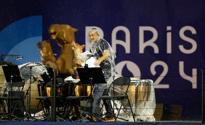 Un músico recoge partituras mojadas por la lluvia caída en Trocadero, este viernes.