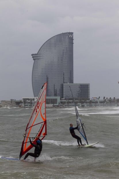 Dos surfistas aprovechan el viento en la playa de la Barceloneta, en Barcelona.