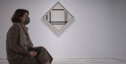 Una mujer sentada frente a una obra de Mondrian.