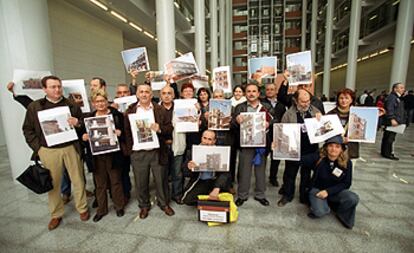 Representantes del sindicato CC OO, ayer en la Ciudad de la Justicia, con fotos de obras que incumplen las normas de seguridad.