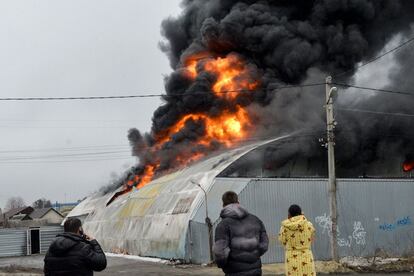 Varios transeúntes observan el incendio de un edificio tras un nuevo bombardeo ruso sobre la ciudad de Jarkóv, este miércoles. Los países de la Unión Europea, EE UU y el Reino Unido han apoyado ante el Consejo de Derechos Humanos de la ONU la creación de una comisión de investigación de posibles crímenes de guerra perpetrados por las tropas rusas en su incursión en Ucrania, que se votará este viernes y ante la que sólo Rusia, China y Venezuela se han manifestado en contra.