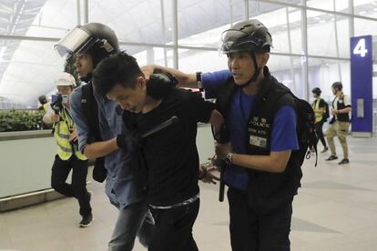 Un manifestante es detenido por la policía en el interior del aeropuerto de Hong Kong.