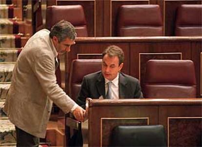 El líder de IU, Gaspar Llamazares, habla con el secretario general del PSOE, José Luis Rodríguez Zapatero, durante el debate.