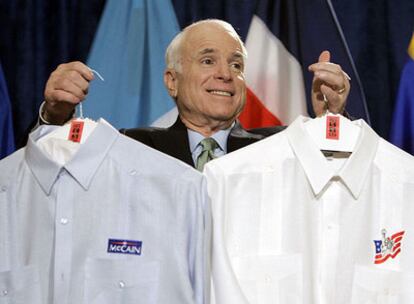 John McCain sostiene unas camisas que le entregó un ex prisionero político cubano, ayer en Miami.