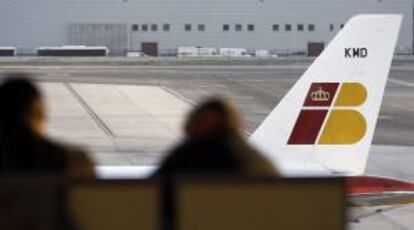 Dos personas ante un avión de Iberia, en el aeropuerto de Barajas. EFE/Archivo