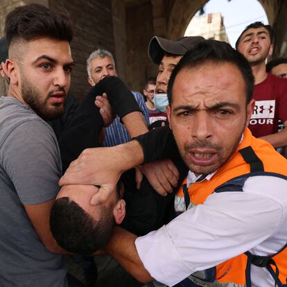 Palestinian medics evacuate a wounded protester amid clashes with Israeli security forces in Jerusalem's Old City on May 10, 2021, as a planned march marking Israel's 1967 takeover of the holy city threatened to further inflame tensions. (Photo by EMMANUEL DUNAND / AFP)