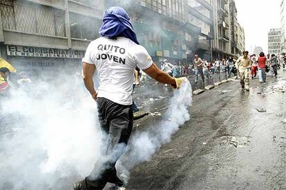 Un manifestante lanza ayer en Quito un bomba de gas en mitad de las protestas populares.