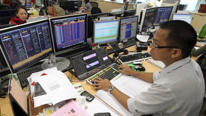 Un corredor de bolsa con el sistema de Bloomberg
