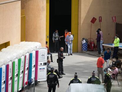 Persones accedeixen al pati d'un dels pavellons passant per un detector de metalls.