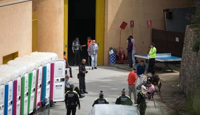 Persones accedeixen al pati d'un dels pavellons passant per un detector de metalls.