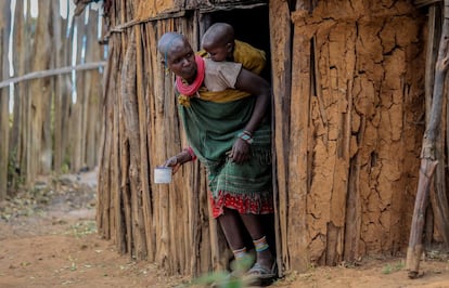 Una joven samburu sale con sus hijos de su pequeña casa, un tipo de vivienda llamado 'manyatta'.