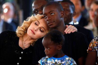 Madonna se apoya sobre el hombro de su hijo David Banda, que sujeta a su hermano pequeño, durante la inauguración del hospita.