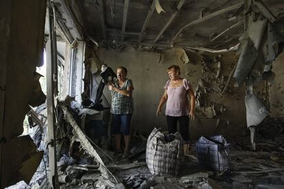 Dos mujeres examinan los daños registrados en su piso tras un reciente bombardeo en la localidad de Yasinovataya, en la región de Donetsk (Ucrania).