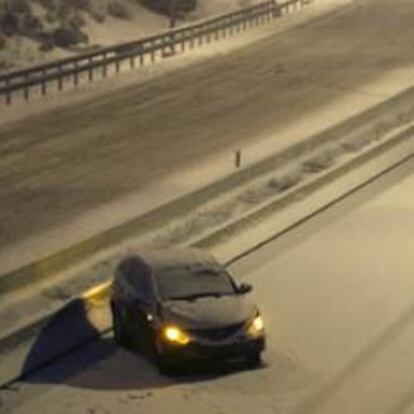 Varios coches circulan por la M-50 en Las Rozas, cubierta por la nieve después de las fuertes nevadas que se han registrado durante toda la tarde.