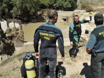 Los agentes, antes de hallar el cad&aacute;ver del hombre arrastrado por la riada en Iznalloz.